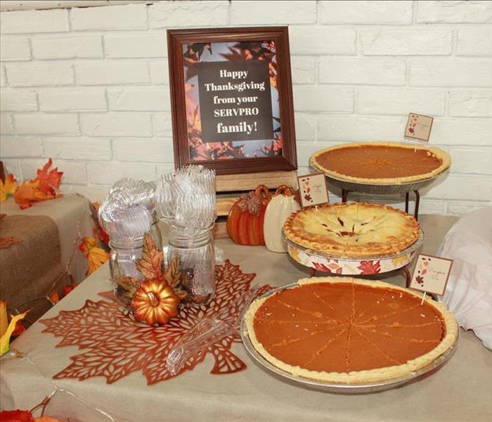 assortment of pumpkin and apple pies on a table decorated with Thanksgiving elements