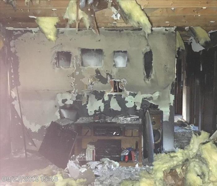 living room with soto and smoke damage on the walls, ceiling collapsing, insulation falling from ceiling 