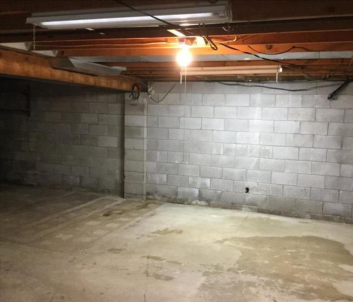 concrete basement with signs of water on the ground