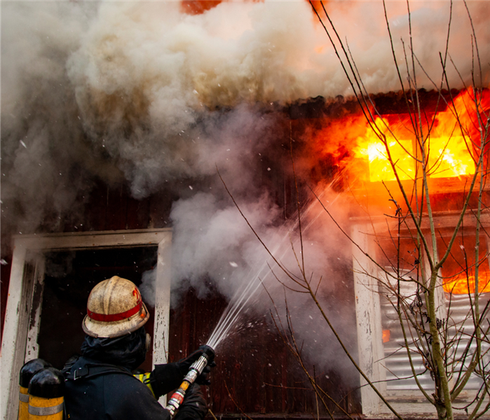 firefighter putting fire out in house
